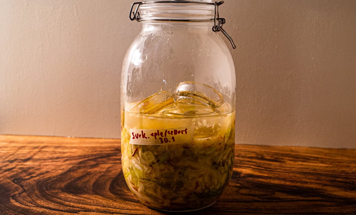 Et glass med fermentert surkål, selleri og eple.